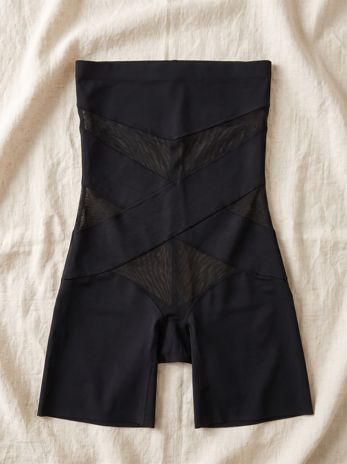 Faja short negra extendida en plano sobre lino crudo